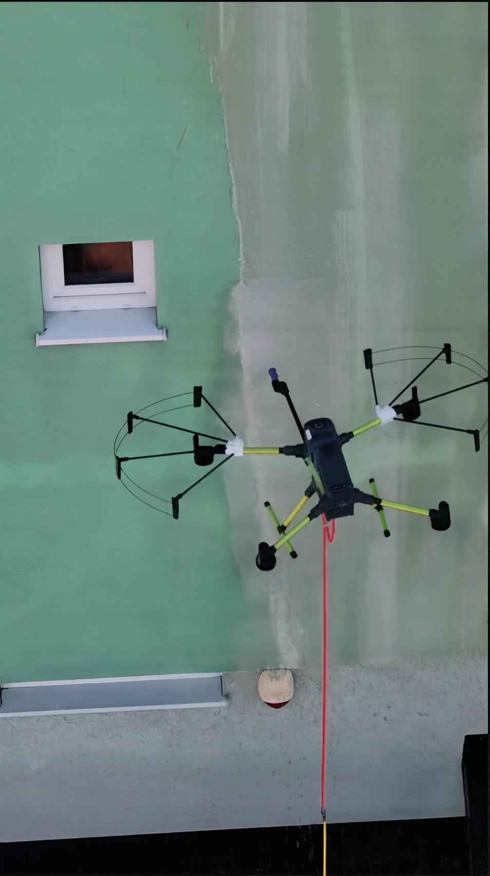 Dron DCS czyszczący elewację wysokiego budynku