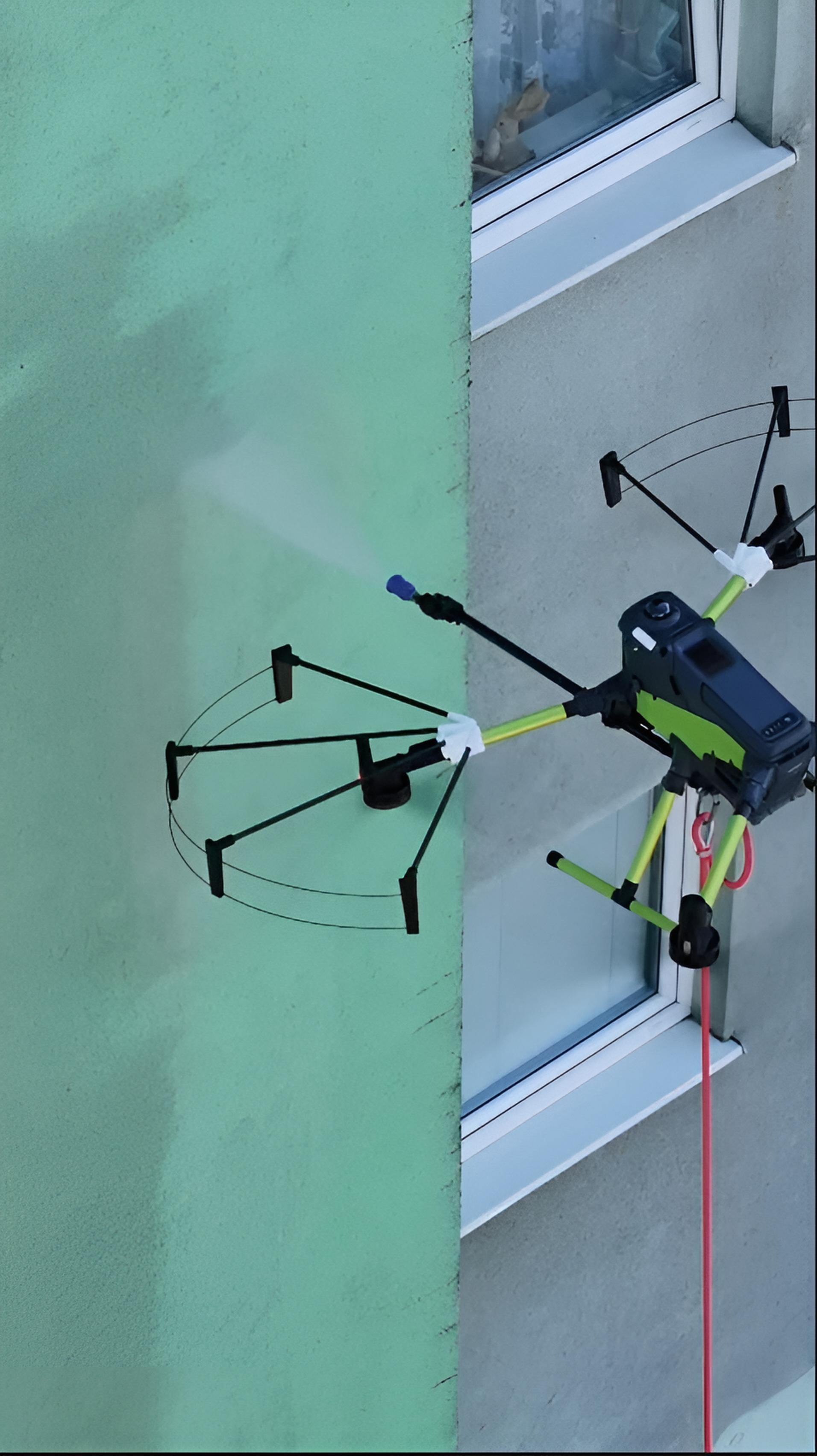 Dron DCS myjący elewację budynku wodą pod wysokim ciśnieniem